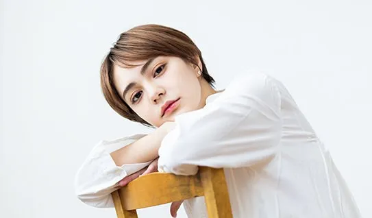 椅子にもたれるショートヘアの女性