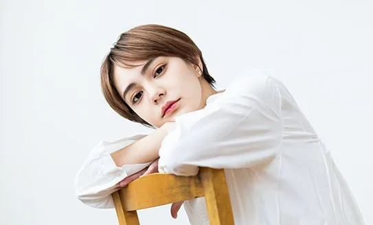椅子にもたれるショートヘアの女性